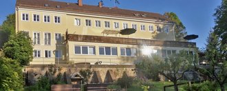 Haus Ammersee Aussenaufnahme: gelb gestrichenes Gebäude mit großer Terassen und einem Obst- und Kräutergarten